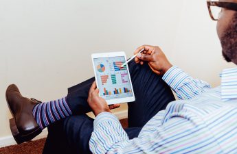 man looking at property management software reports on tablet